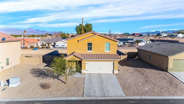 view of front of property with driveway, a residential view, an attached garage, fence, and stucco siding