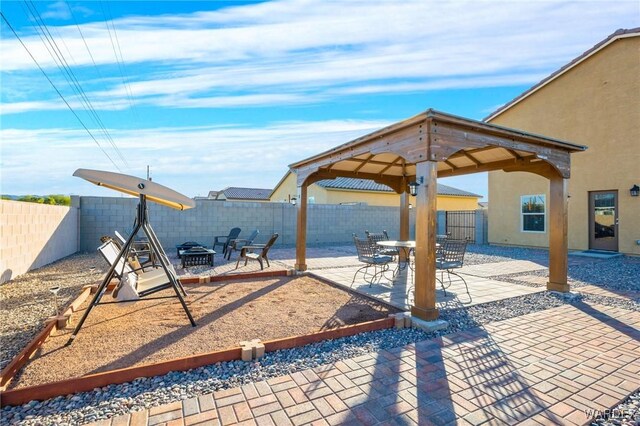 view of patio with a fenced backyard, a fire pit, and a gazebo