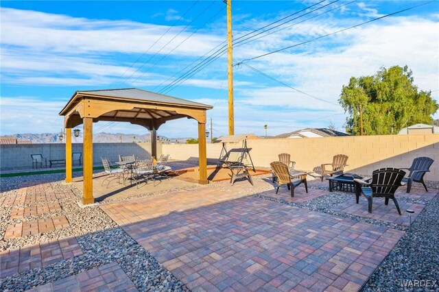 view of patio / terrace with an outdoor fire pit, a fenced backyard, and a gazebo