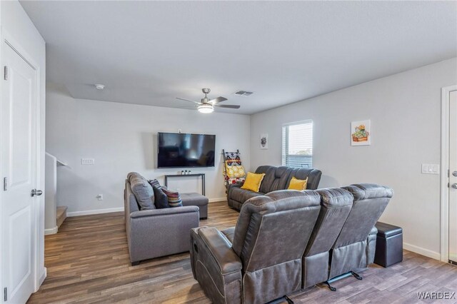 living room with baseboards, visible vents, ceiling fan, and wood finished floors