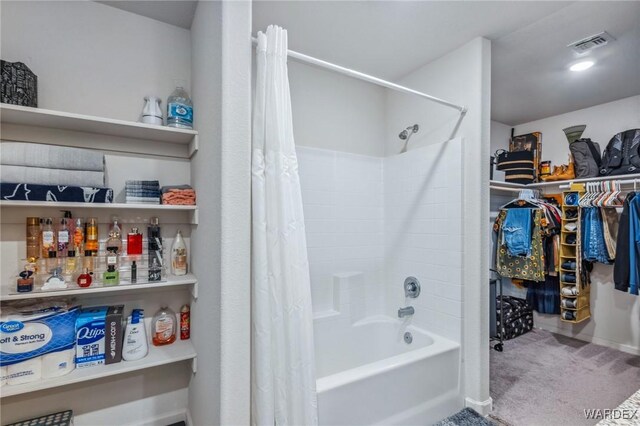 full bath featuring visible vents, a walk in closet, and shower / bath combo with shower curtain