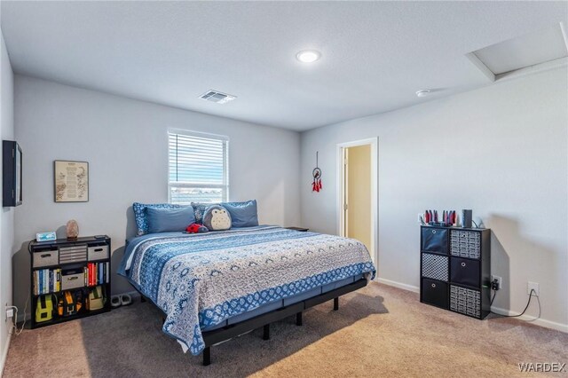 carpeted bedroom featuring attic access, visible vents, and baseboards