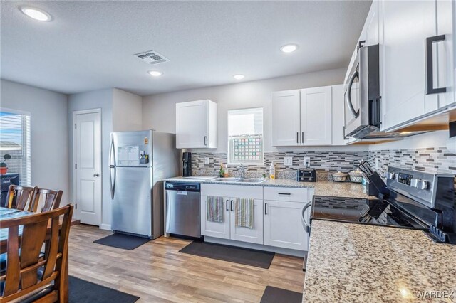 kitchen featuring plenty of natural light, visible vents, appliances with stainless steel finishes, and white cabinets