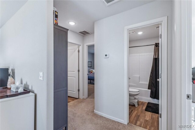 hall featuring recessed lighting, light colored carpet, visible vents, and baseboards