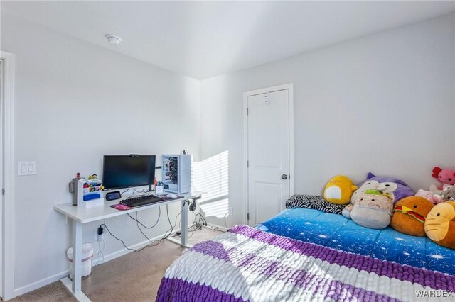 bedroom featuring light carpet and baseboards