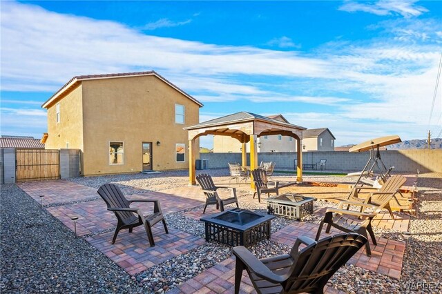 view of patio with a gazebo, an outdoor fire pit, a fenced backyard, and central air condition unit