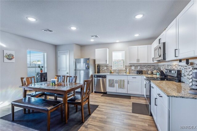 kitchen featuring visible vents, appliances with stainless steel finishes, and white cabinets