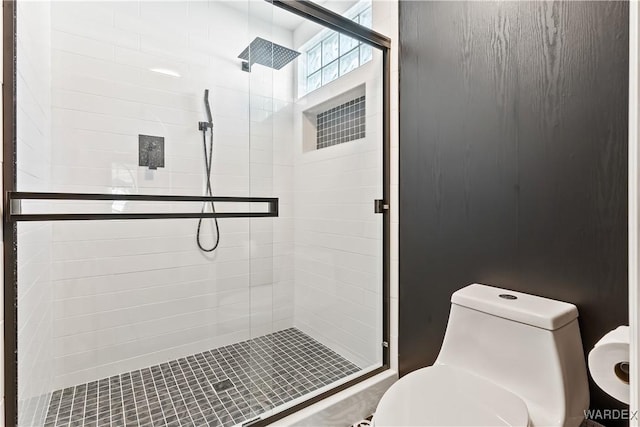 bathroom featuring toilet and a shower stall