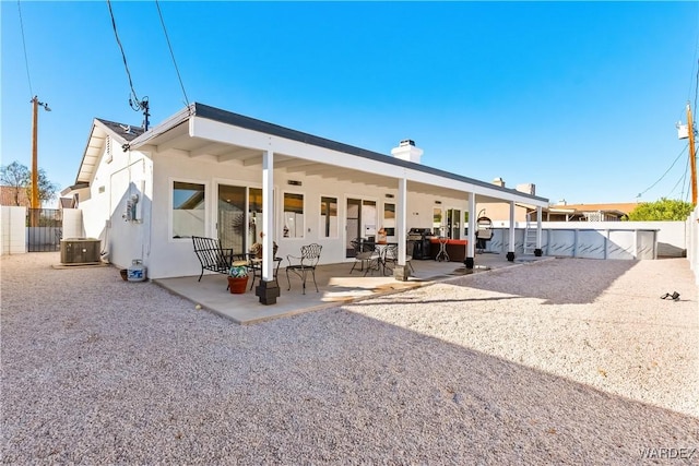 back of property featuring central AC, a patio, a chimney, and a fenced backyard