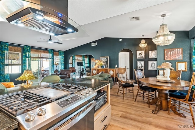 kitchen featuring visible vents, arched walkways, dark countertops, hanging light fixtures, and gas stove