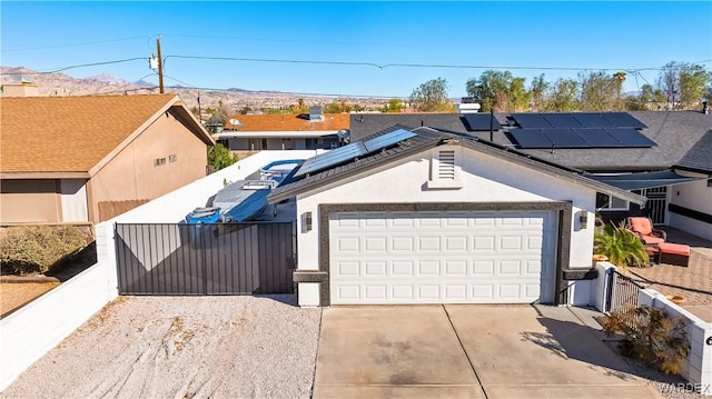 ranch-style home featuring concrete driveway, fence, an attached garage, and stucco siding