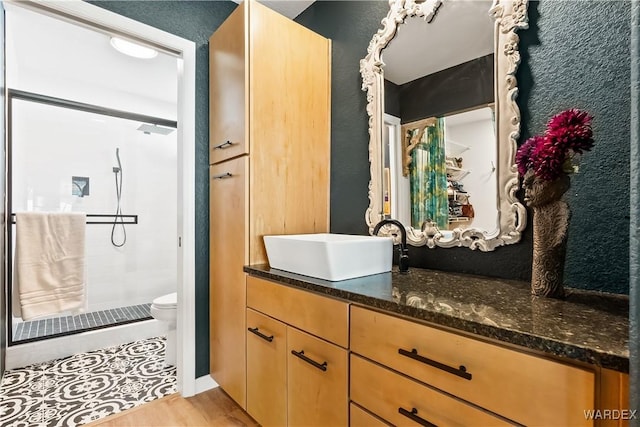 full bath with toilet, wood finished floors, a shower stall, and vanity