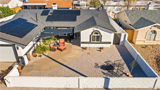 view of front of house with solar panels, roof with shingles, and an outdoor living space