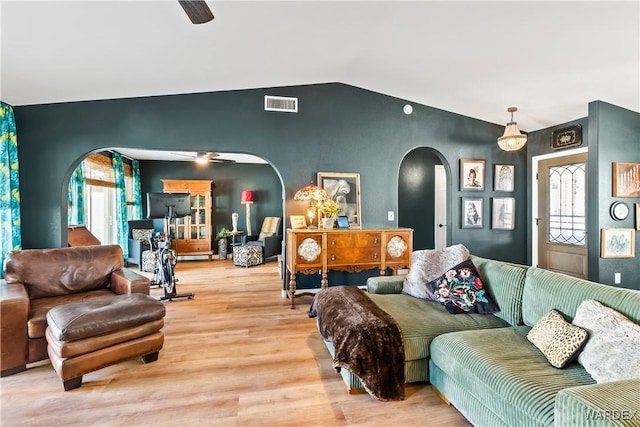 living room featuring a healthy amount of sunlight, visible vents, arched walkways, and ceiling fan