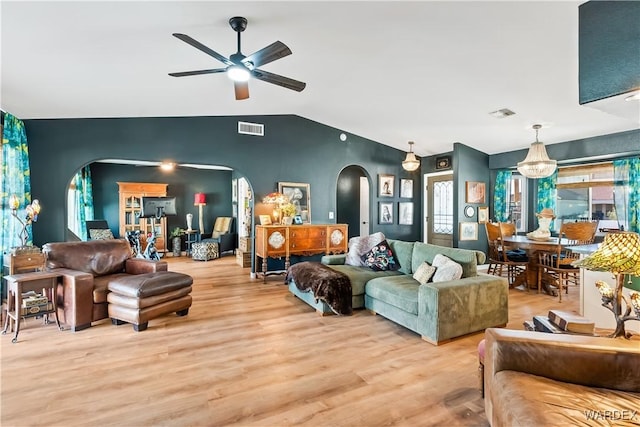 living room featuring light wood finished floors, visible vents, arched walkways, lofted ceiling, and ceiling fan