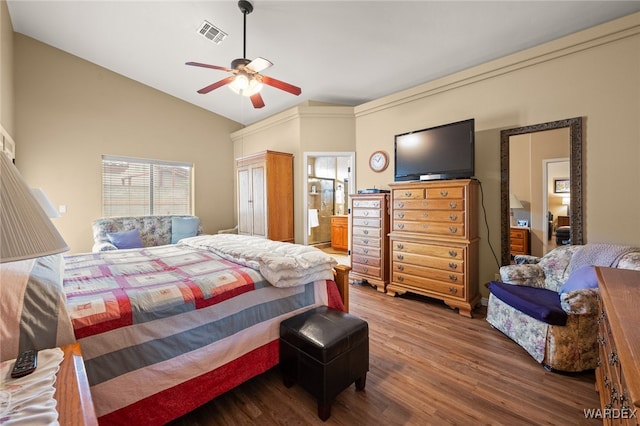 bedroom with visible vents, ensuite bathroom, a ceiling fan, wood finished floors, and vaulted ceiling