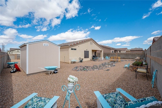 rear view of property featuring a tiled roof, a fenced backyard, a storage shed, an outdoor structure, and a patio area