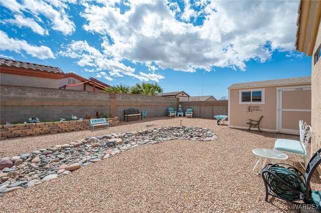 view of yard featuring a fenced backyard, a shed, a patio area, and an outdoor structure