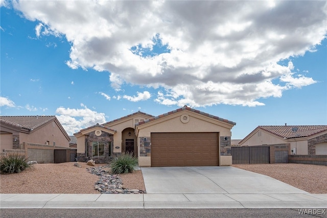 mediterranean / spanish house with a gate, fence, driveway, an attached garage, and stucco siding