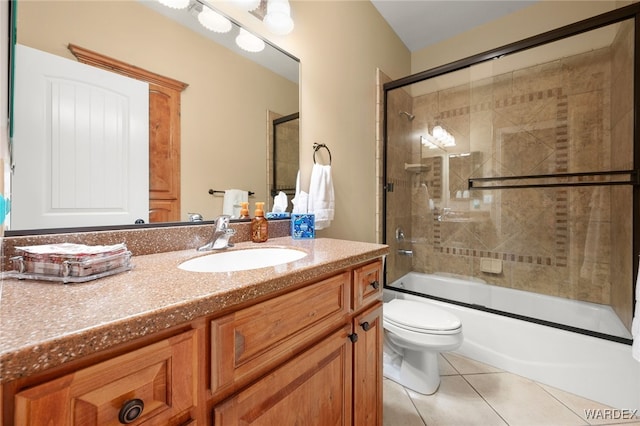 bathroom with tile patterned floors, shower / bath combination with glass door, vanity, and toilet