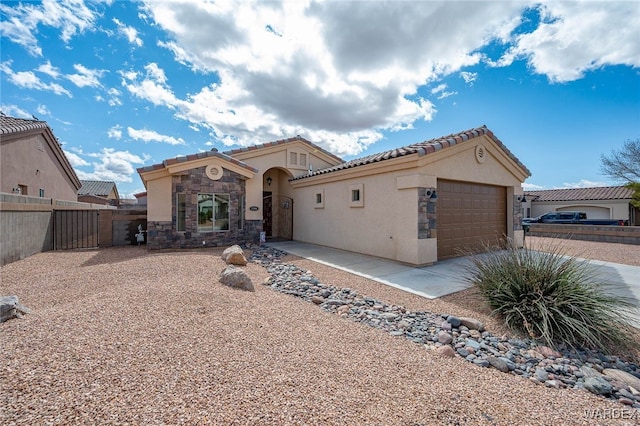 mediterranean / spanish-style house with stucco siding, driveway, a tile roof, fence, and an attached garage