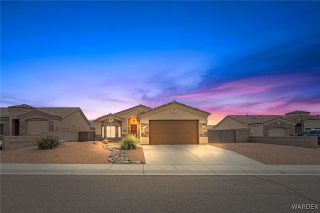 view of front of home with an attached garage, a fenced front yard, stucco siding, driveway, and a gate