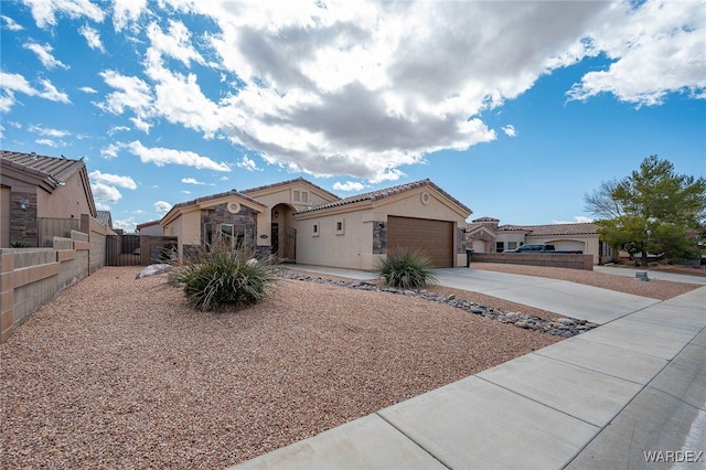 view of front of property with fence, driveway, an attached garage, stucco siding, and a tile roof