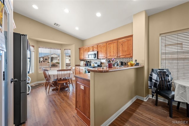 kitchen featuring dark wood finished floors, visible vents, appliances with stainless steel finishes, and lofted ceiling