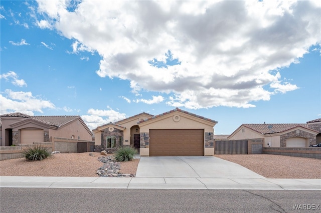 mediterranean / spanish home with a gate, fence, driveway, an attached garage, and stucco siding