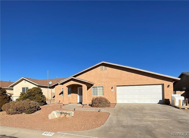 ranch-style house featuring a garage, driveway, and stucco siding