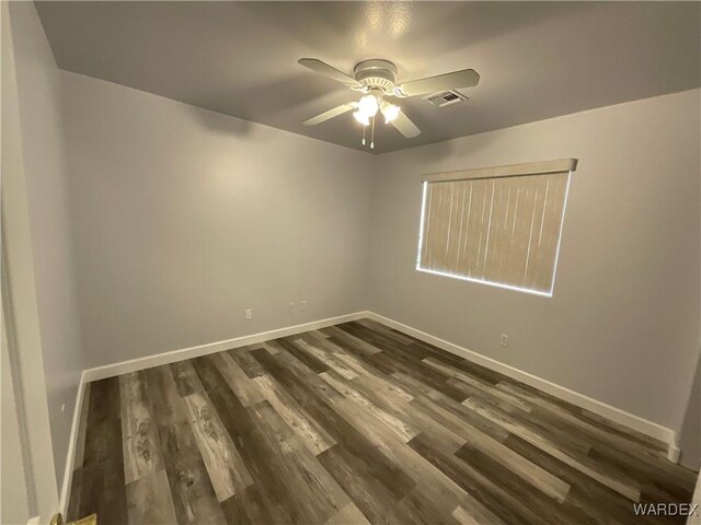 unfurnished room featuring ceiling fan, dark wood-style flooring, visible vents, and baseboards