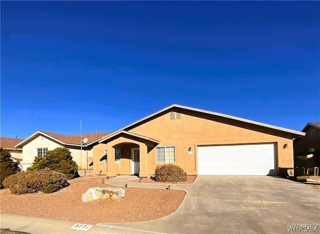 ranch-style house with an attached garage, concrete driveway, and stucco siding