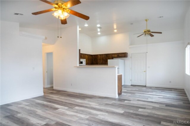 interior space with visible vents, baseboards, light wood-style floors, high vaulted ceiling, and recessed lighting