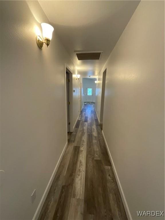 corridor featuring attic access, dark wood finished floors, visible vents, and baseboards