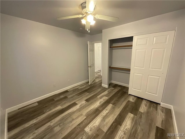 unfurnished bedroom featuring dark wood-type flooring, a closet, a ceiling fan, and baseboards