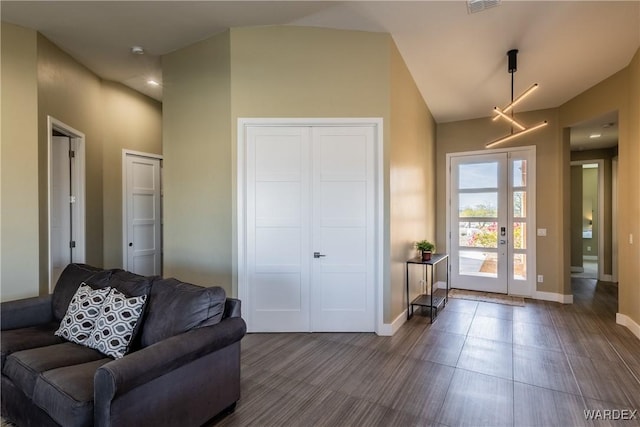 living room featuring lofted ceiling, baseboards, visible vents, and french doors