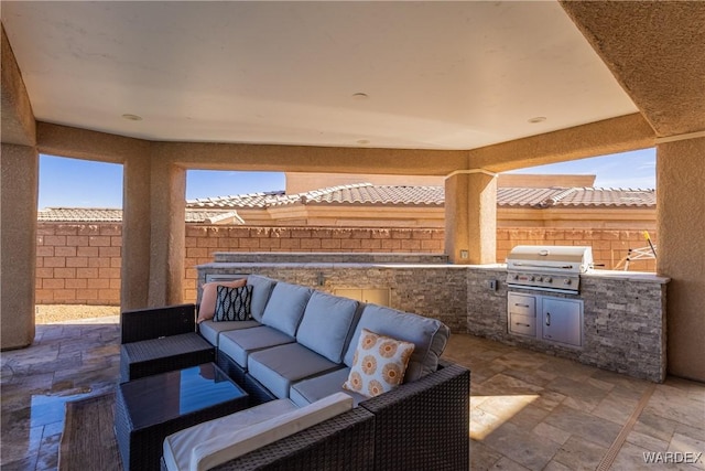 view of patio with area for grilling, a grill, and fence