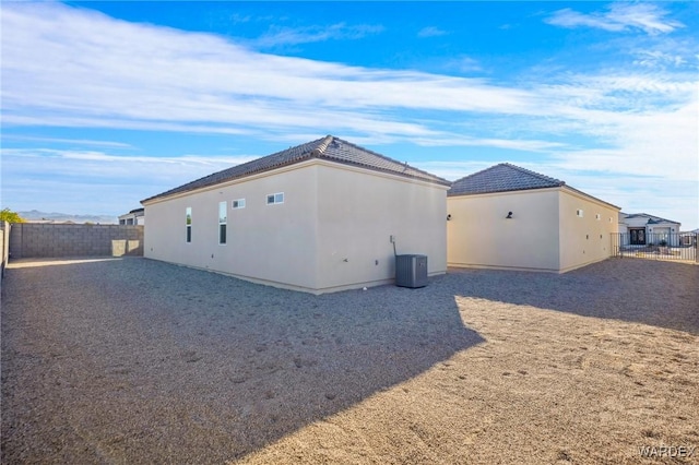 view of home's exterior with fence, cooling unit, and stucco siding