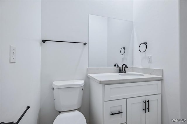 half bath featuring vanity and toilet