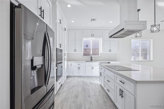 kitchen with appliances with stainless steel finishes, decorative light fixtures, custom exhaust hood, light countertops, and white cabinetry