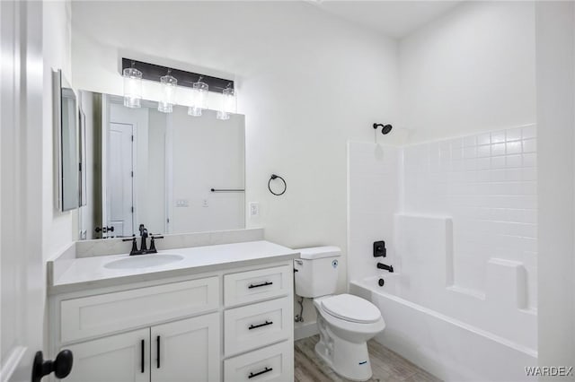 full bathroom featuring toilet, shower / washtub combination, wood finished floors, and vanity