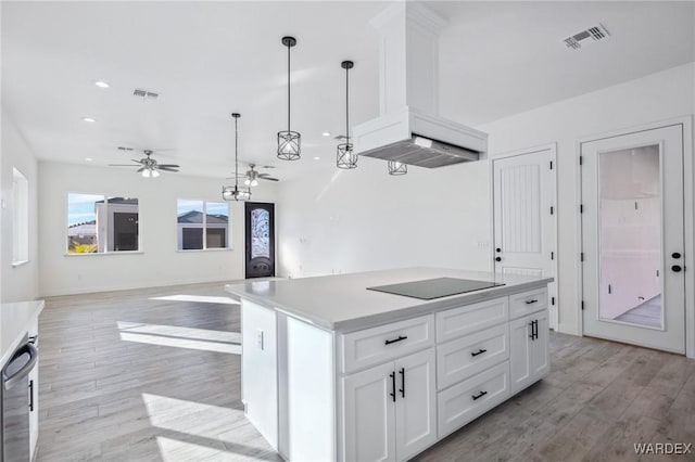 kitchen featuring black electric stovetop, a kitchen island, white cabinets, open floor plan, and hanging light fixtures