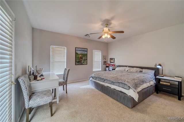 bedroom featuring light carpet, ceiling fan, visible vents, and baseboards