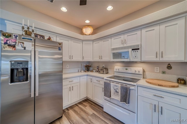 kitchen featuring light stone counters, white appliances, light wood-style flooring, and recessed lighting