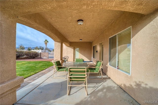 view of patio with outdoor dining space and fence