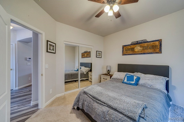 bedroom with carpet, ceiling fan, baseboards, and a closet