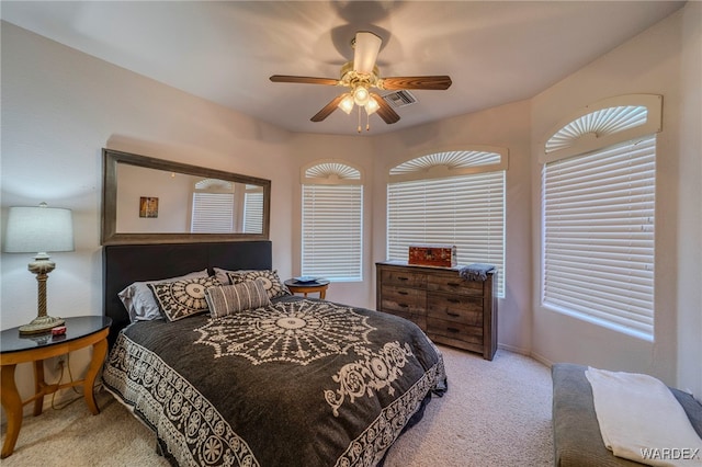 bedroom with light carpet, baseboards, visible vents, and a ceiling fan