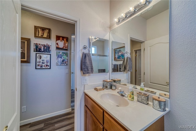 bathroom with baseboards, wood finished floors, and vanity