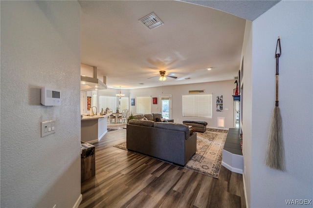 living area featuring dark wood finished floors, visible vents, and baseboards