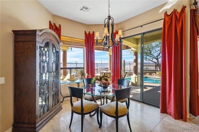 dining room with light tile patterned floors, visible vents, and a notable chandelier